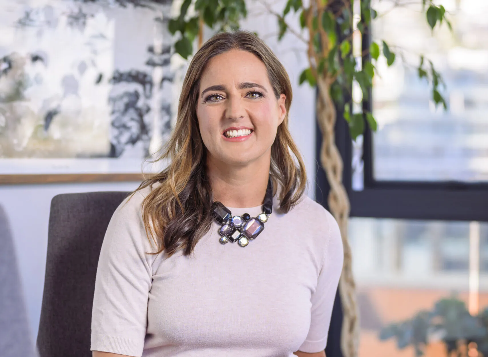 Professional woman sitting in a boardroom with multiple projects and income streams, representing the concept of a portfolio career and career flexibility.